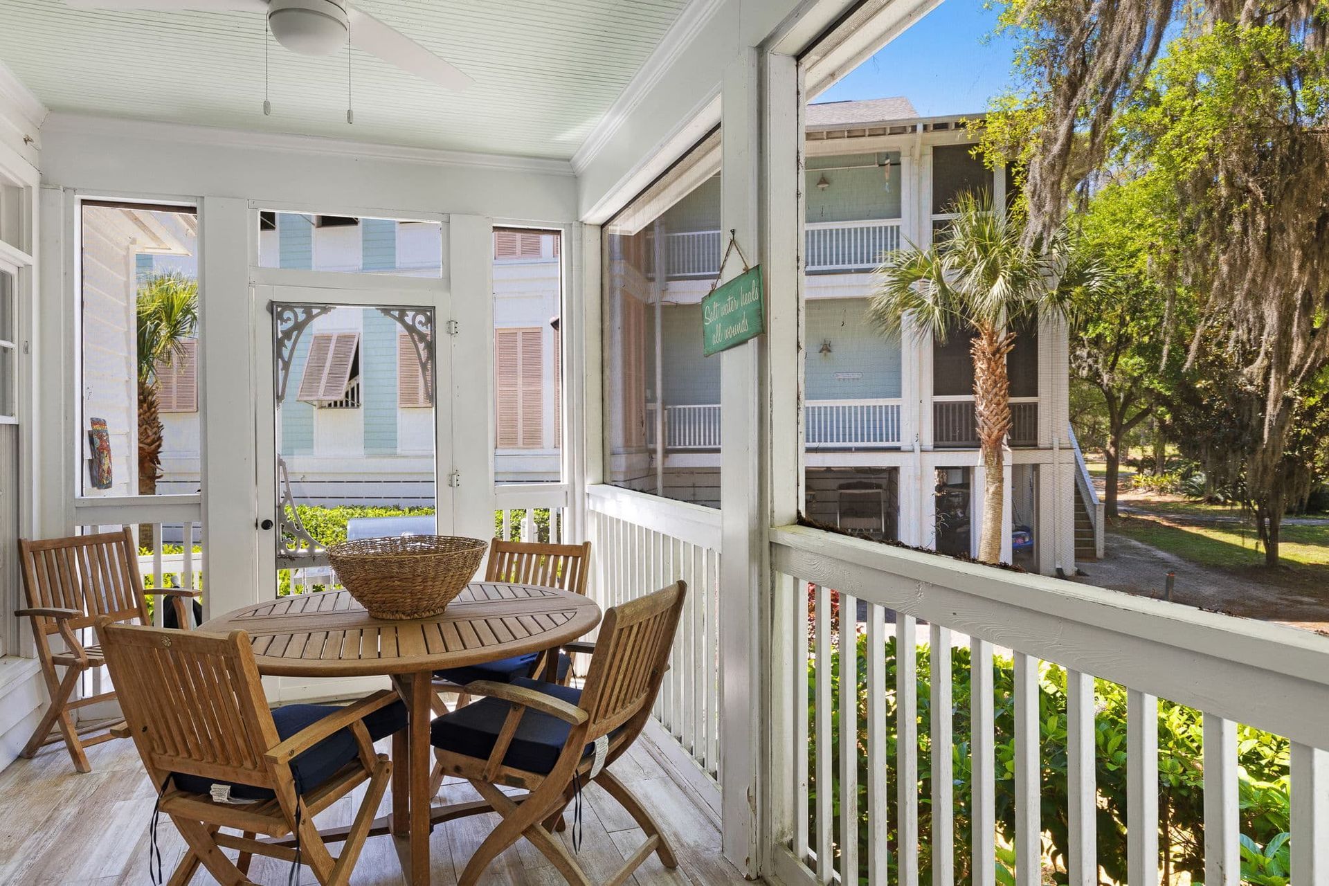 A screened in porch with a table and chairs