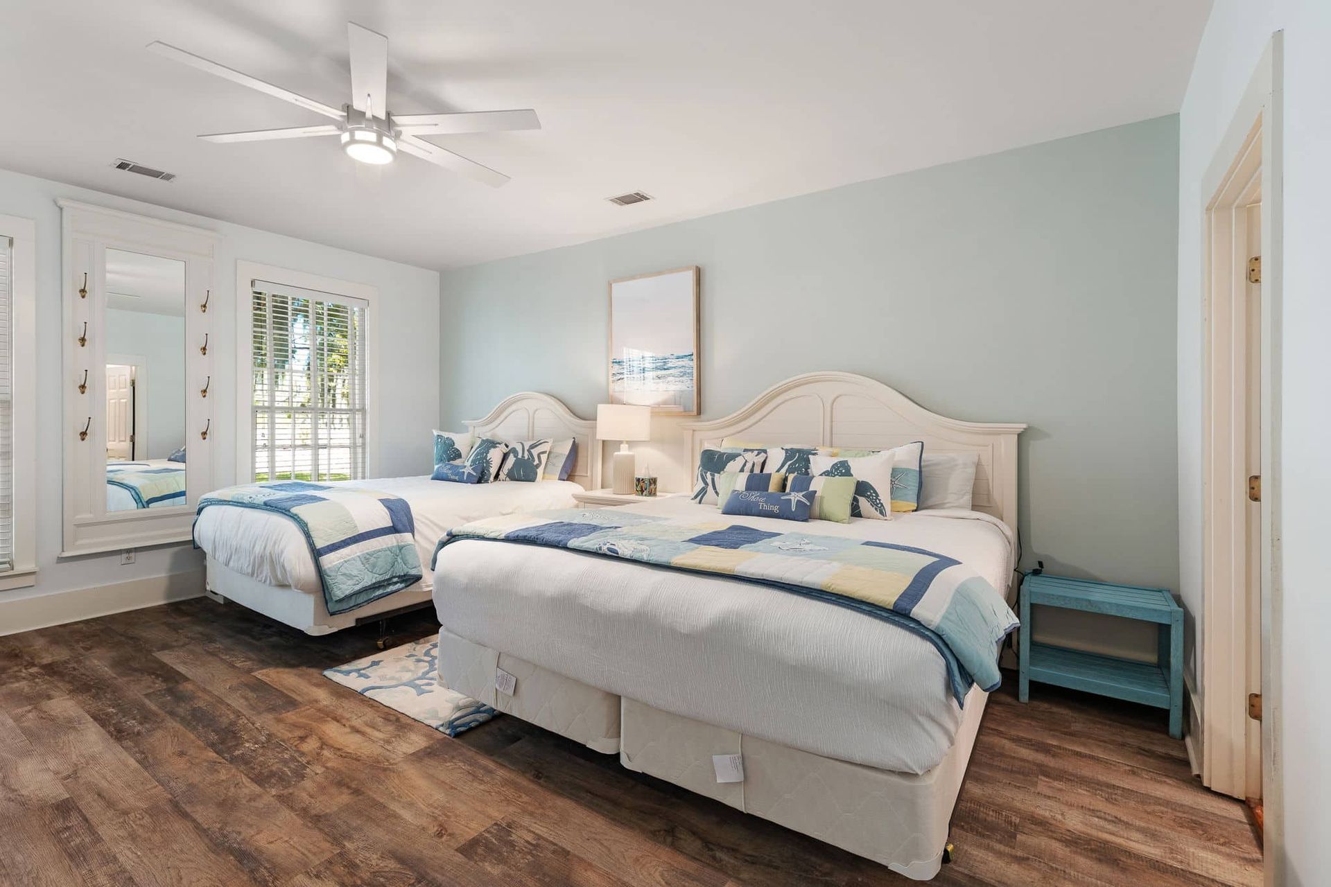 A bedroom with two beds and a ceiling fan.