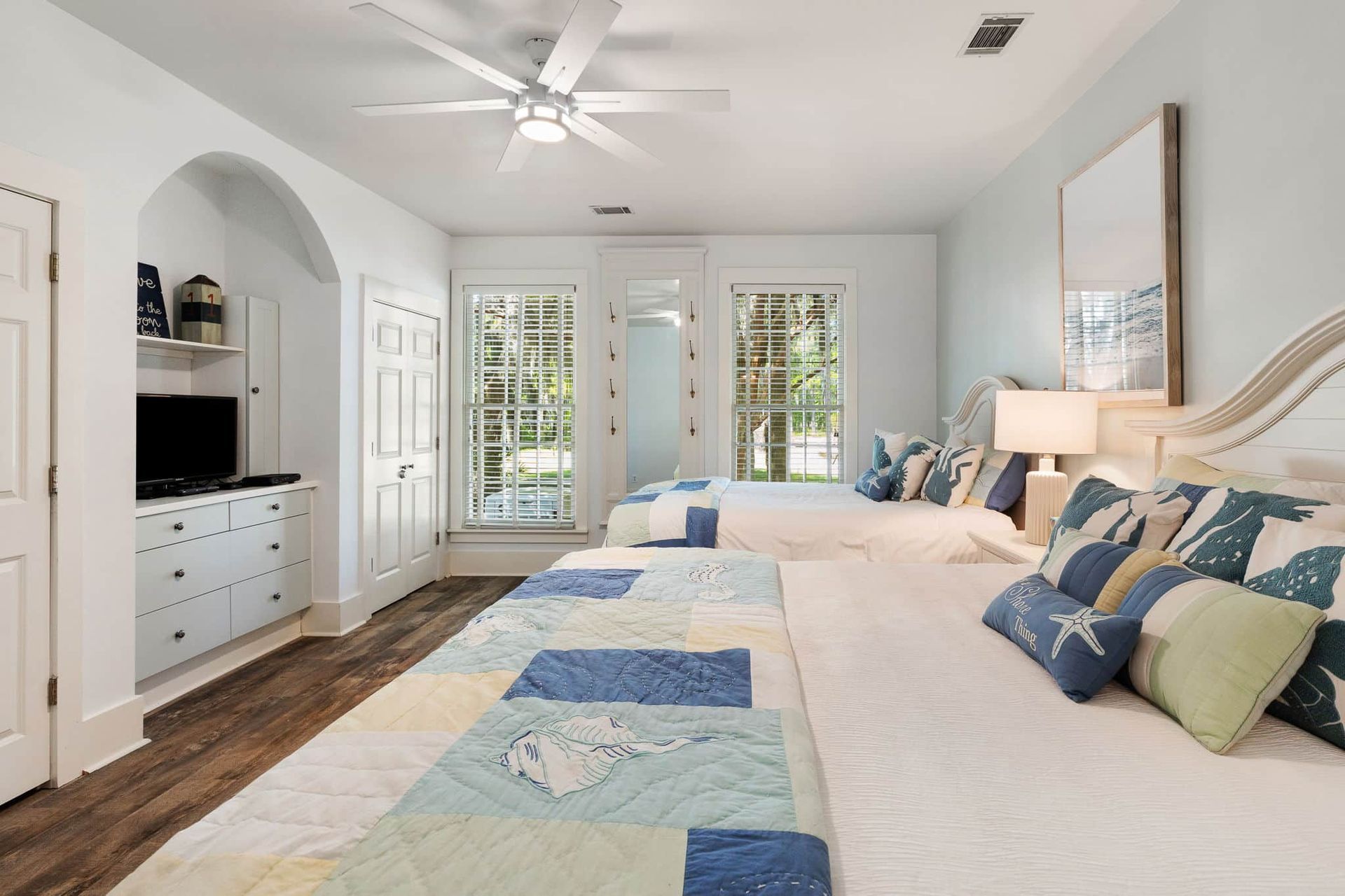 A bedroom with two beds and a ceiling fan.