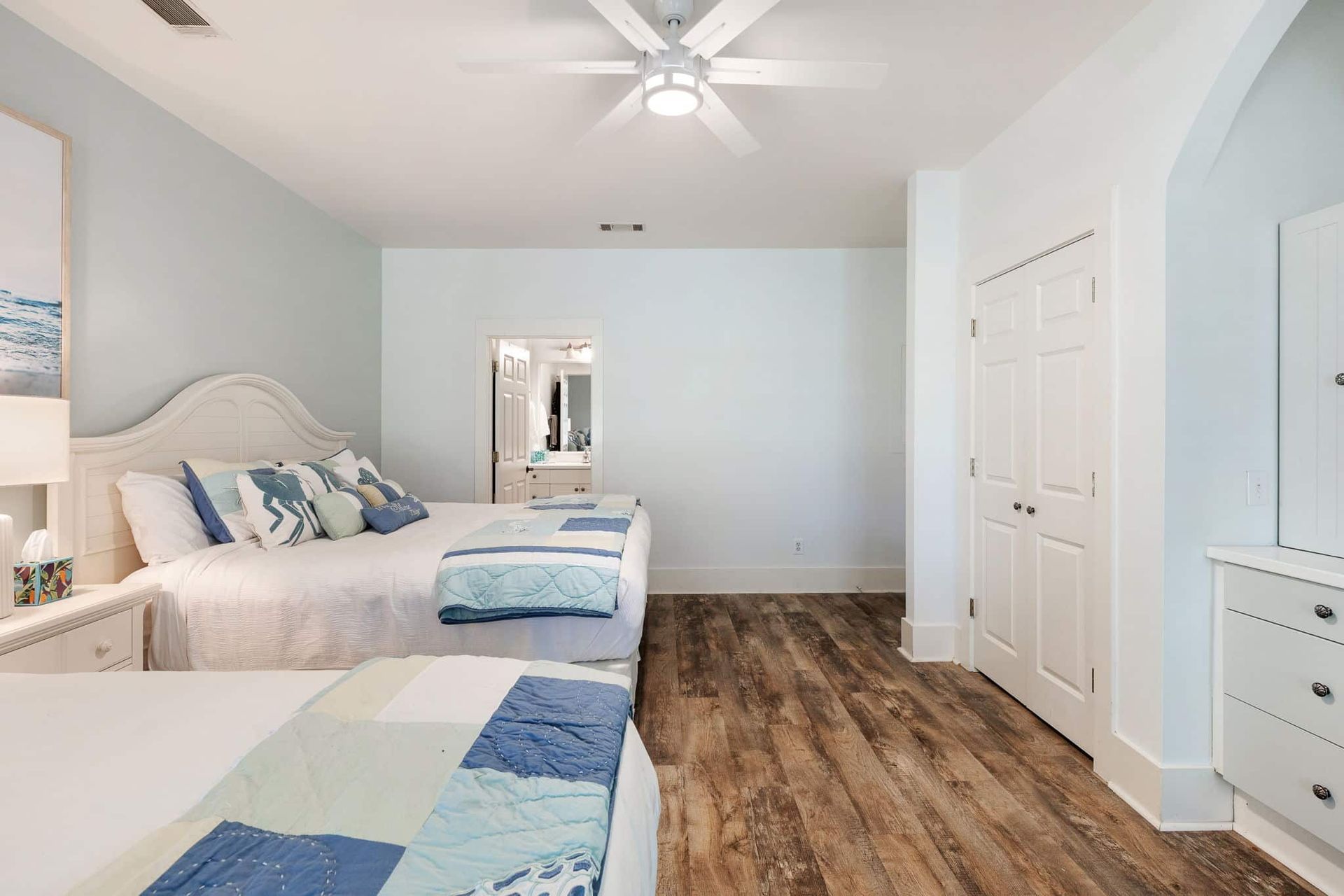 A bedroom with two beds and a ceiling fan.