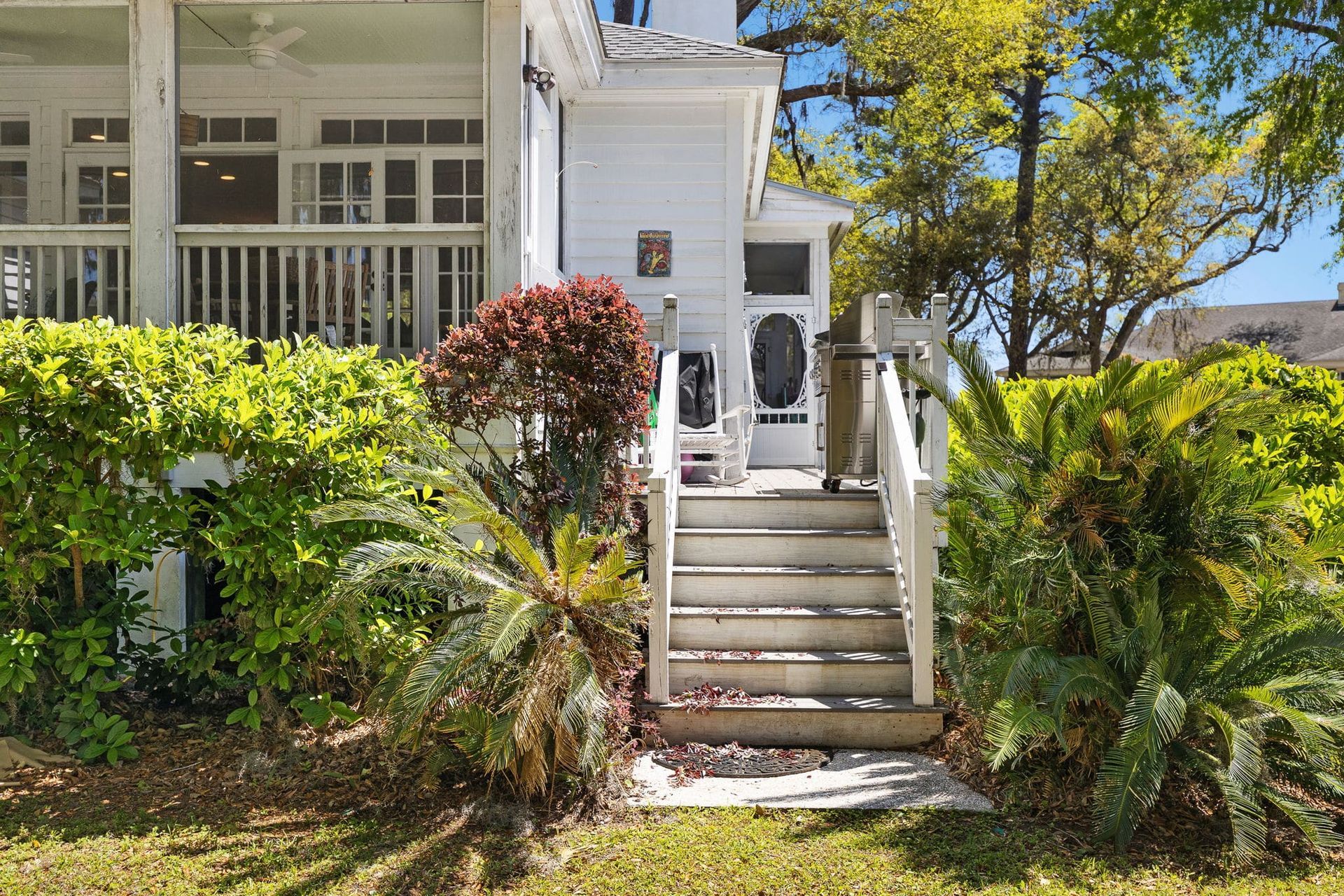 A white house with a porch and stairs leading up to it.