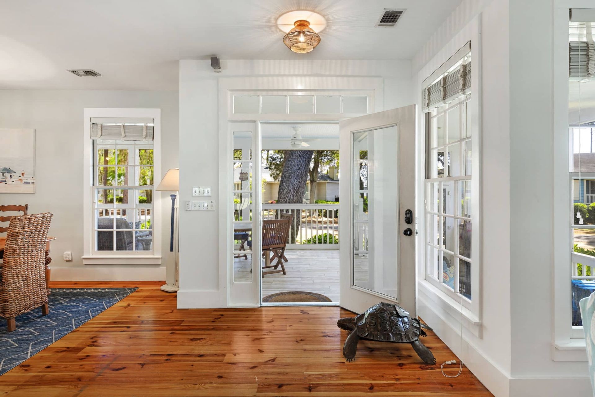 A turtle is sitting on a wooden floor in a living room.