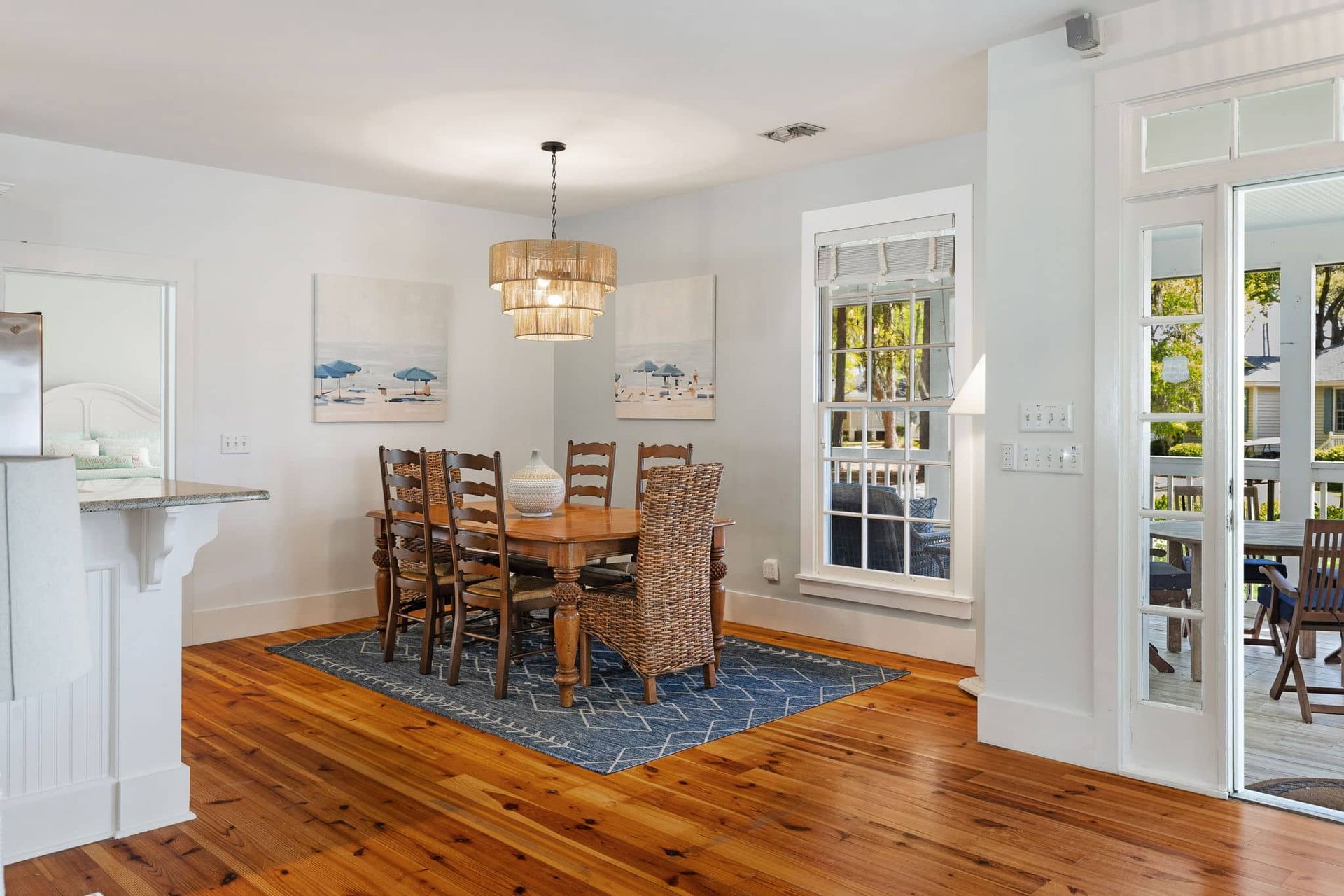 A dining room with a wooden table and chairs and a blue rug.