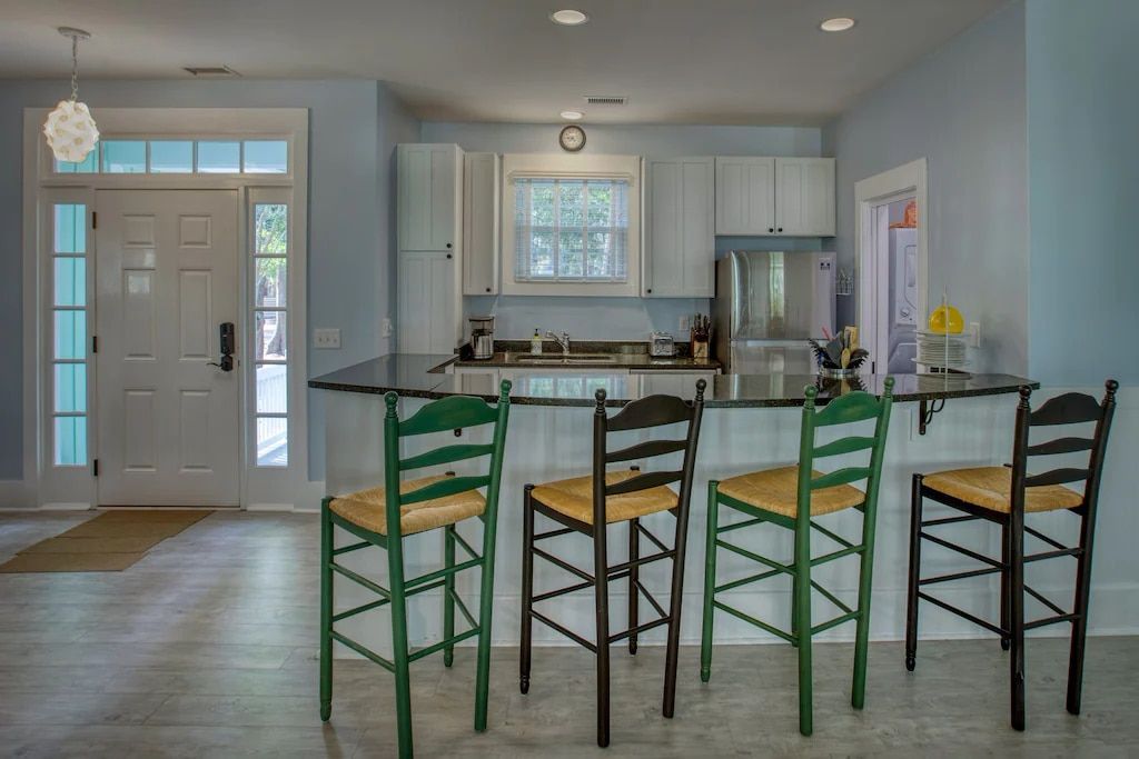 A kitchen with a bar and chairs in it