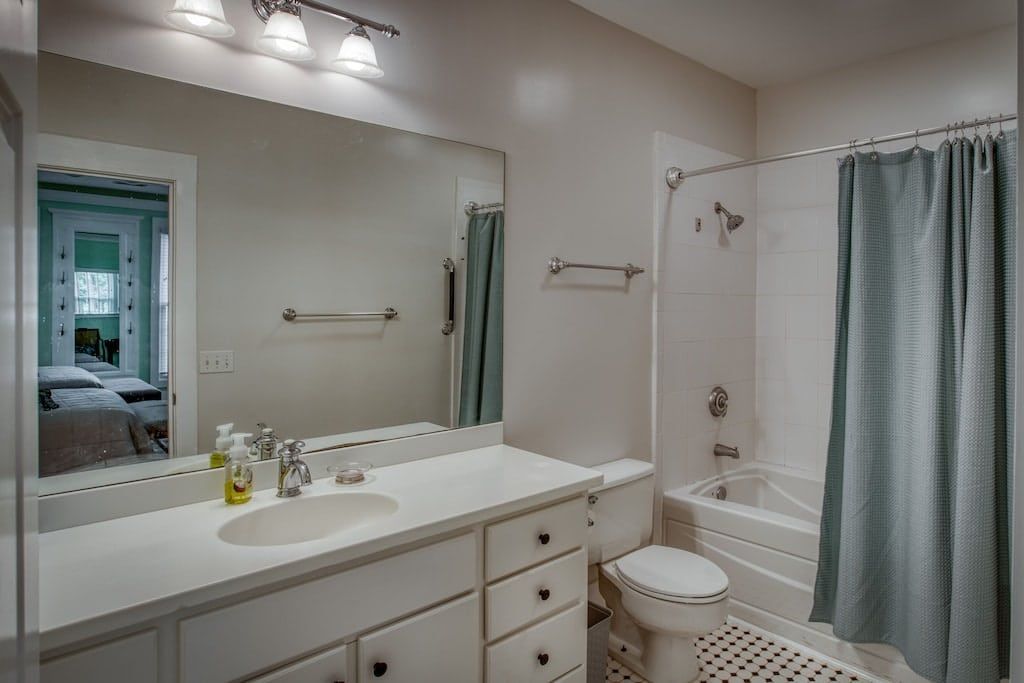 A bathroom with a sink , toilet , tub and mirror.