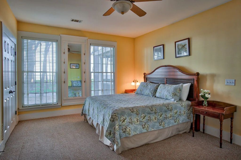 A bedroom with a large bed and a ceiling fan