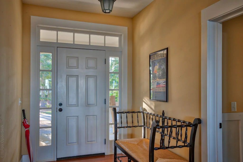 A hallway with a white door and a bench