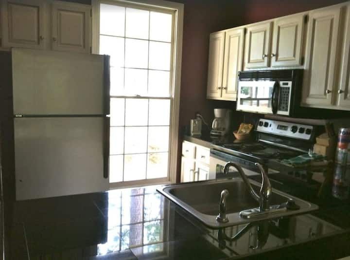 A kitchen with white cabinets and black counter tops