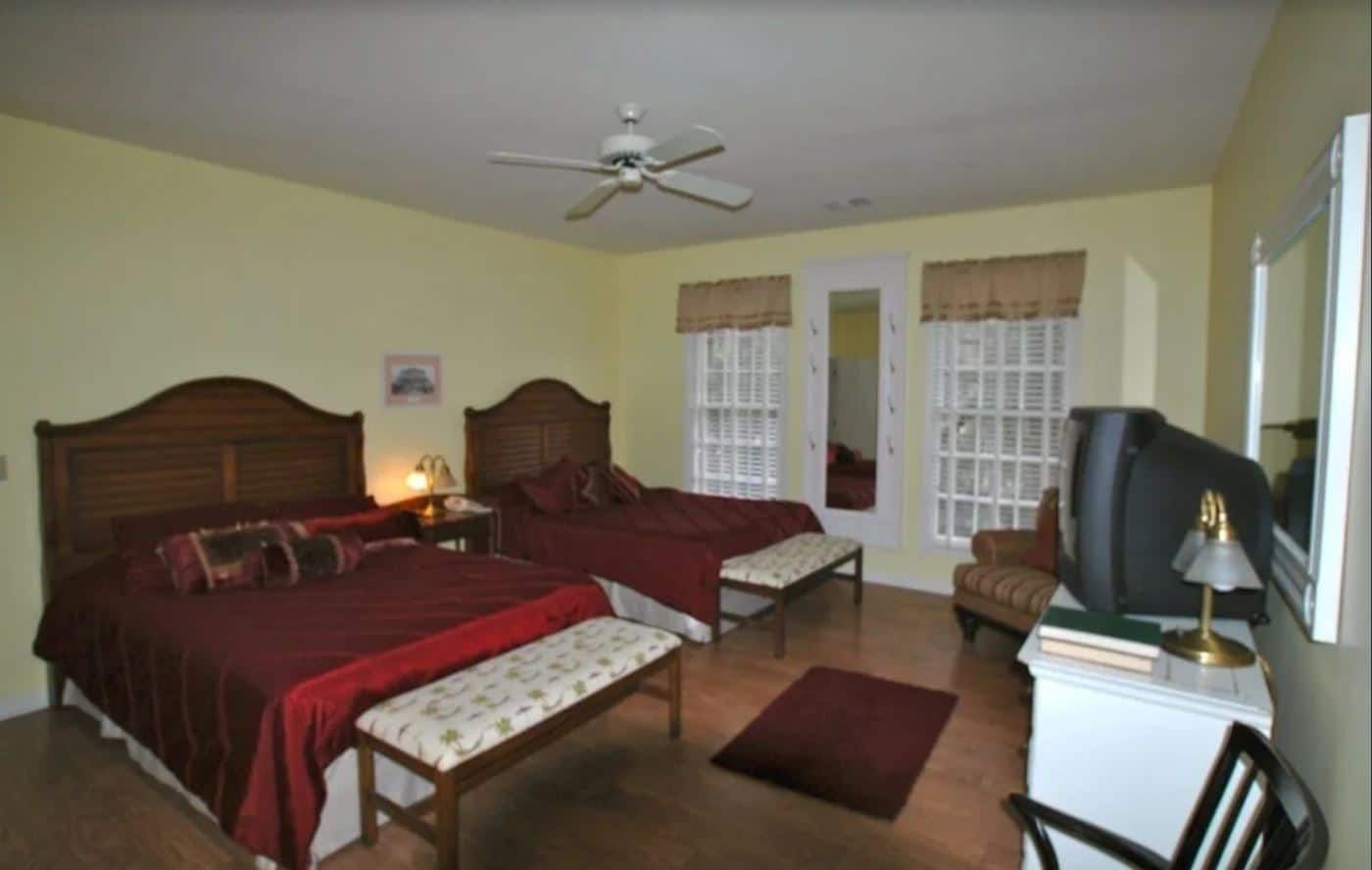 A bedroom with two beds and a flat screen tv