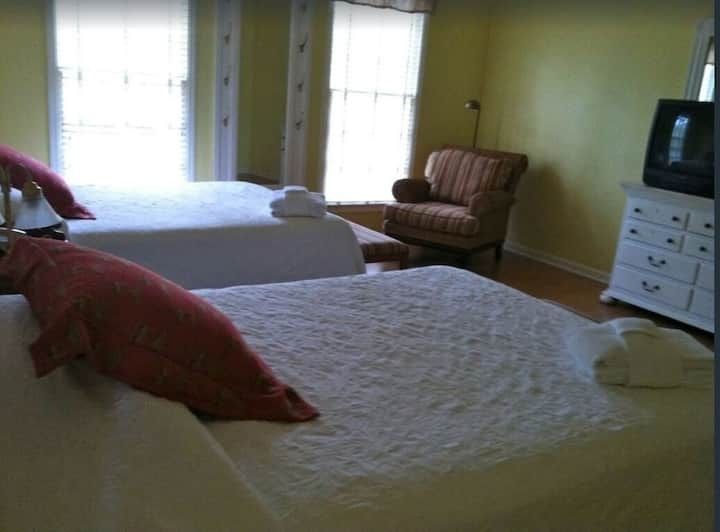 A hotel room with two beds and a chair