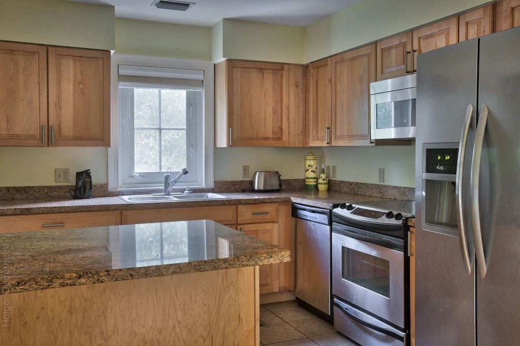 A kitchen with stainless steel appliances and wooden cabinets