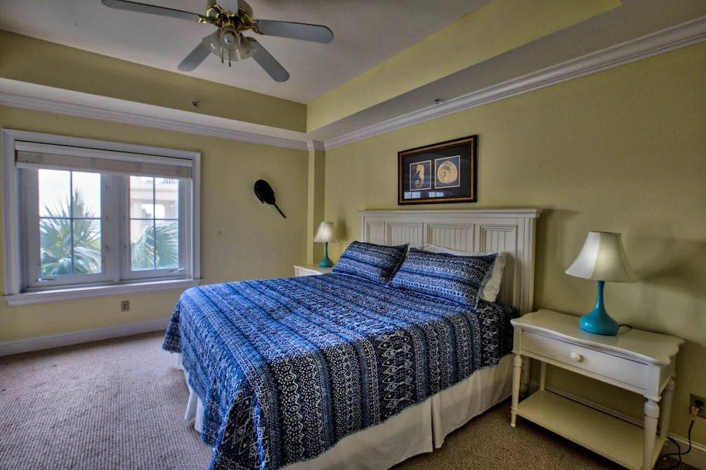 A bedroom with a king size bed and a ceiling fan.