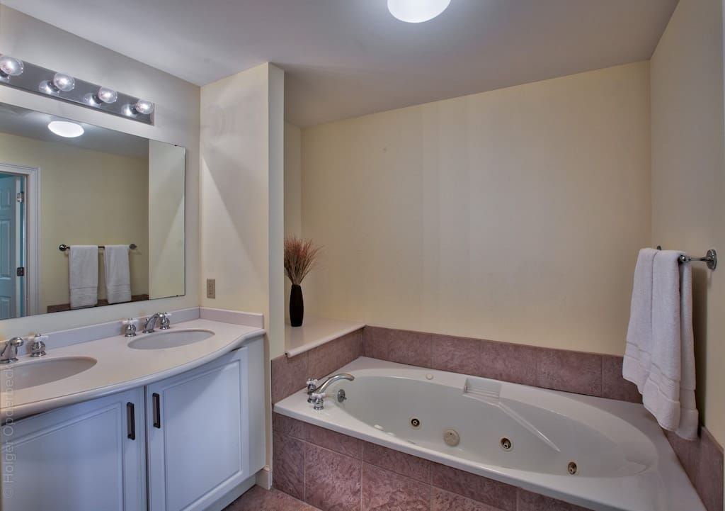 A bathroom with a jacuzzi tub and two sinks.