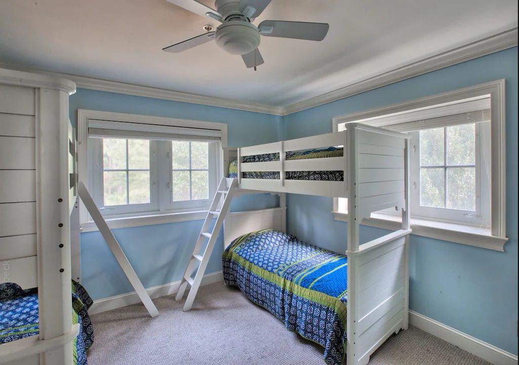 A bedroom with bunk beds and a ceiling fan
