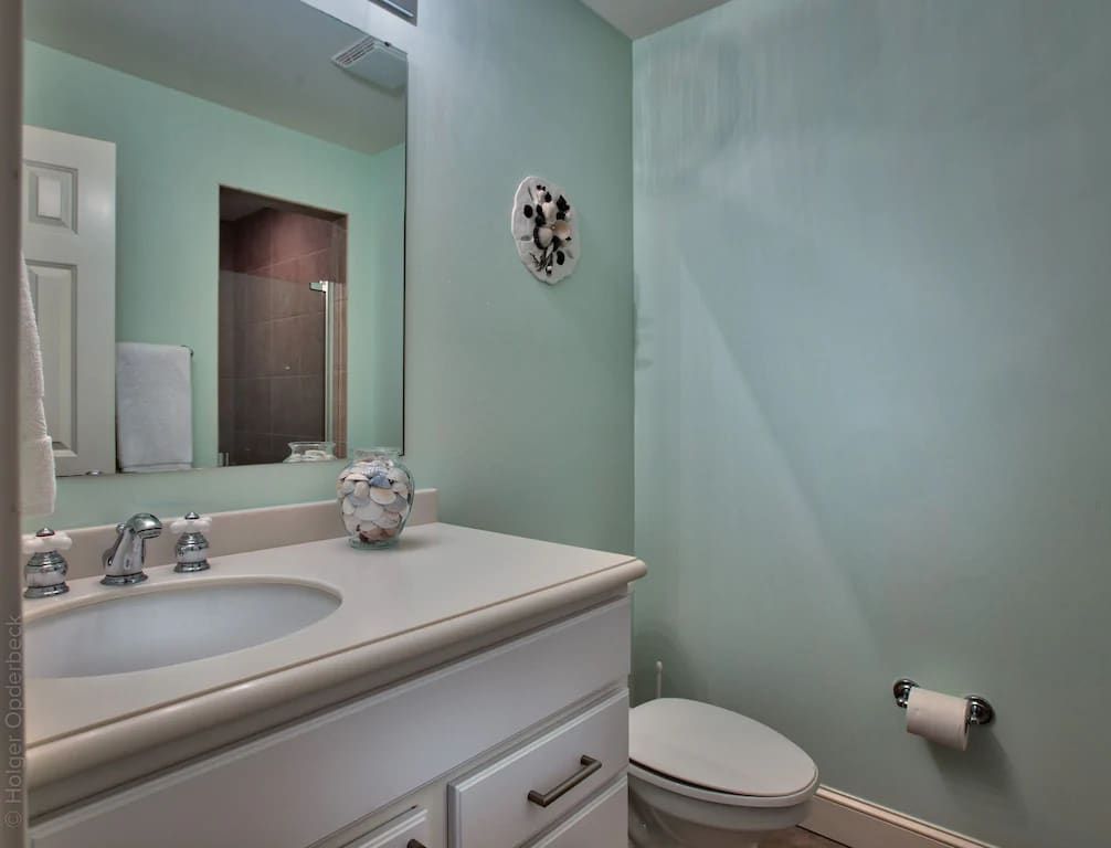 A bathroom with a sink , toilet and mirror.