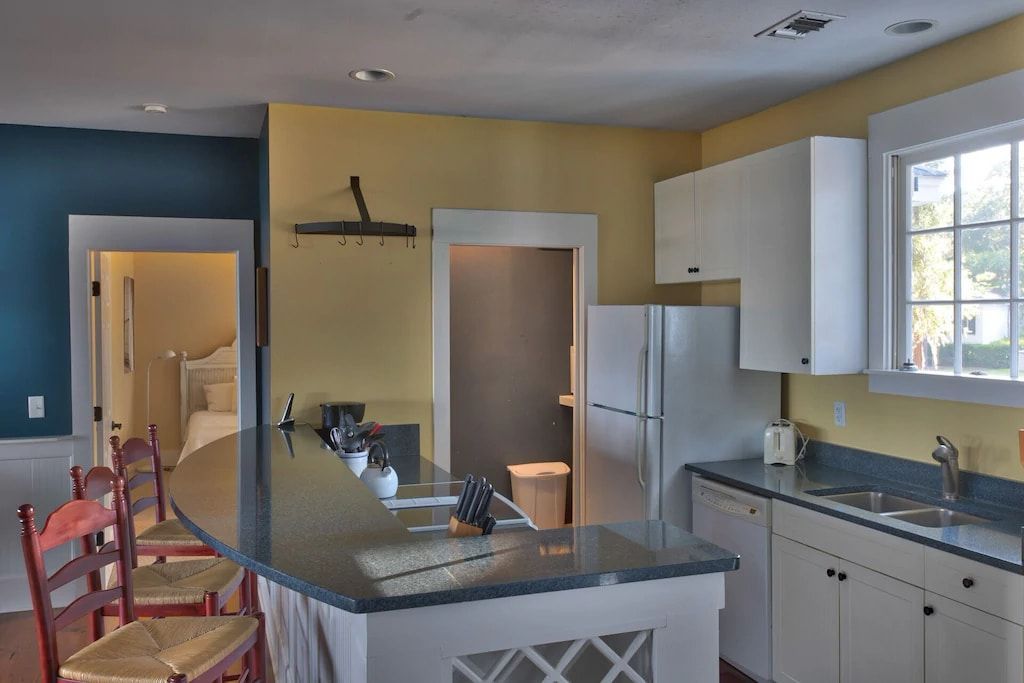 A kitchen with white cabinets and a stainless steel refrigerator