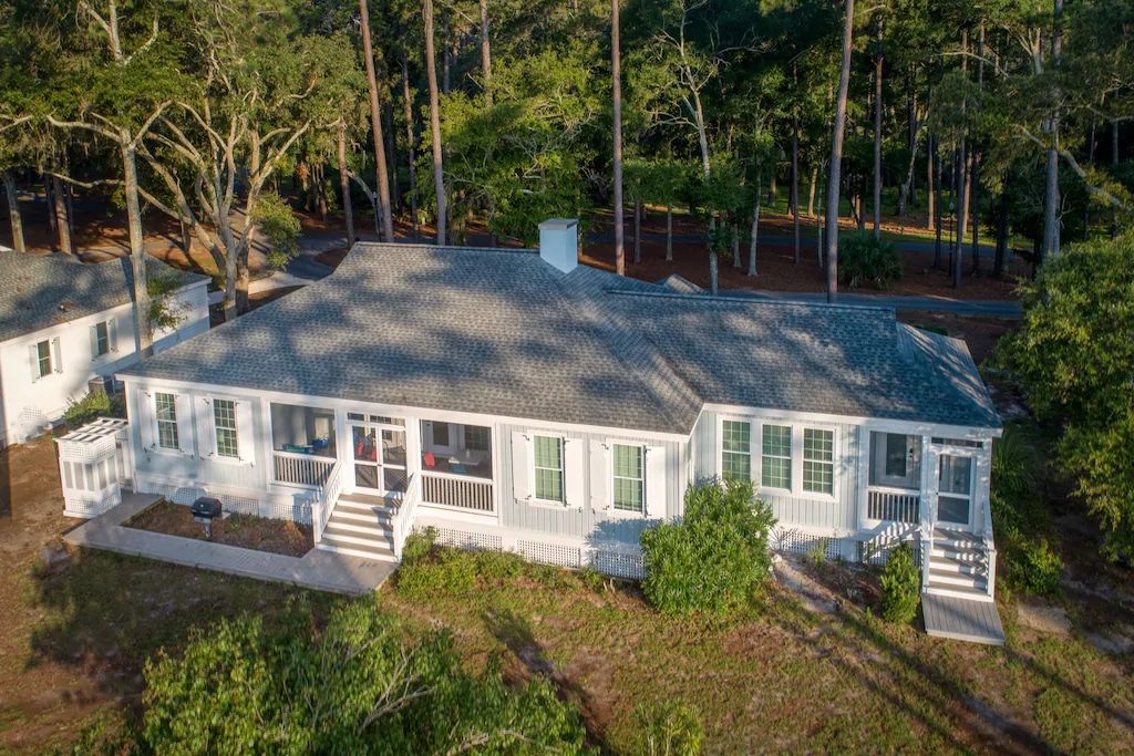 An aerial view of a large white house surrounded by trees.