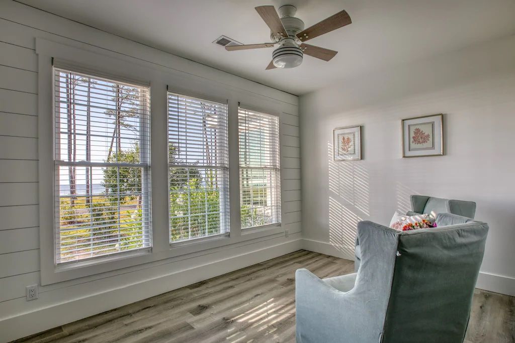 A living room with a chair and a ceiling fan.