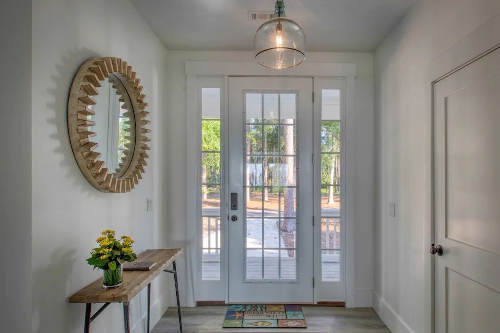 A hallway with a white door and a mirror on the wall.
