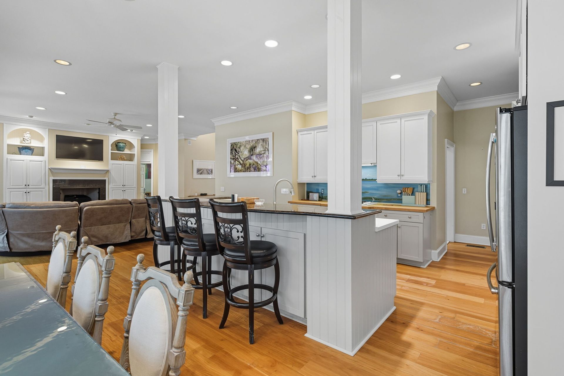 A kitchen with white cabinets , a sink , and a window.