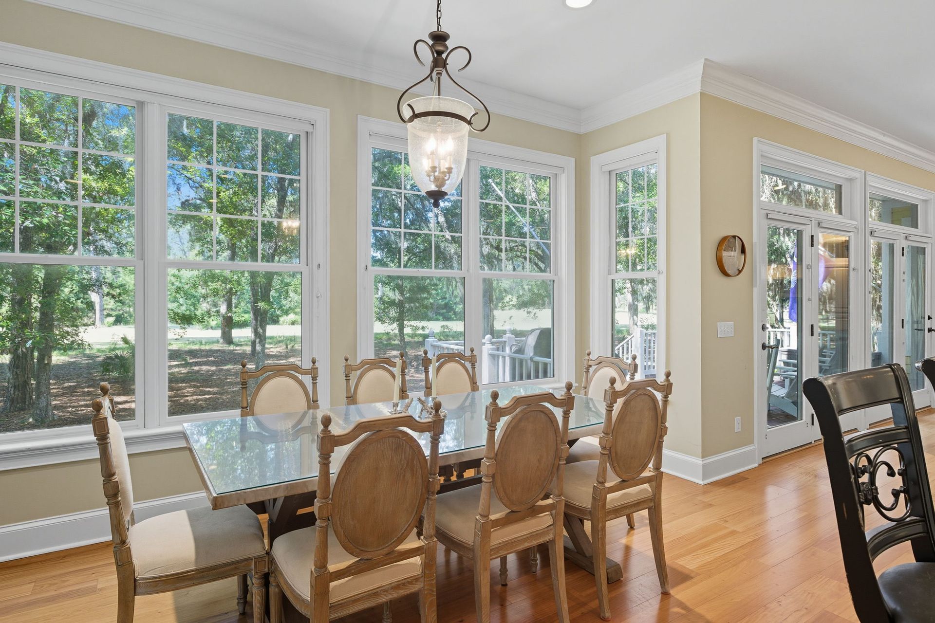A screened in porch with a view of trees and the ocean
