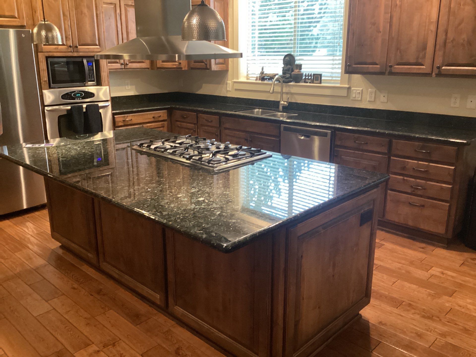 Kitchen with dark granite countertops and a large island with a granite countertop