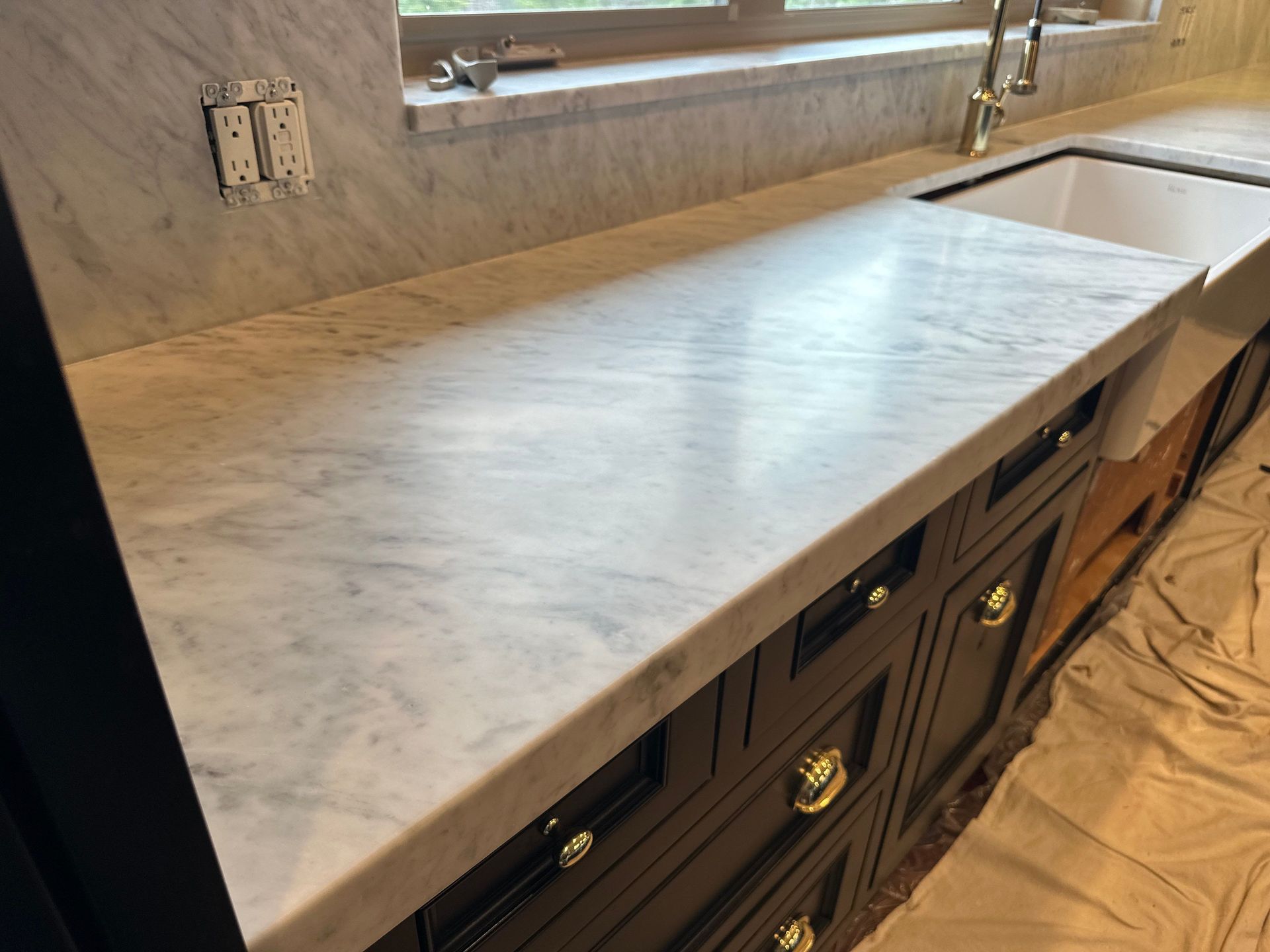 Matte white marble countertop with gray veining in a modern kitchen, after a MORE® AntiEtch® treatment