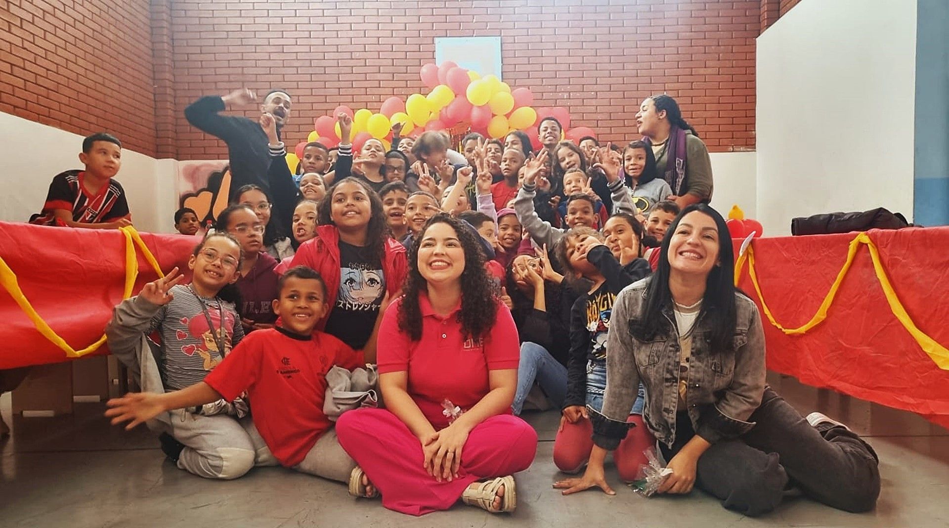 Um grupo de pessoas posando para uma foto com balões ao fundo