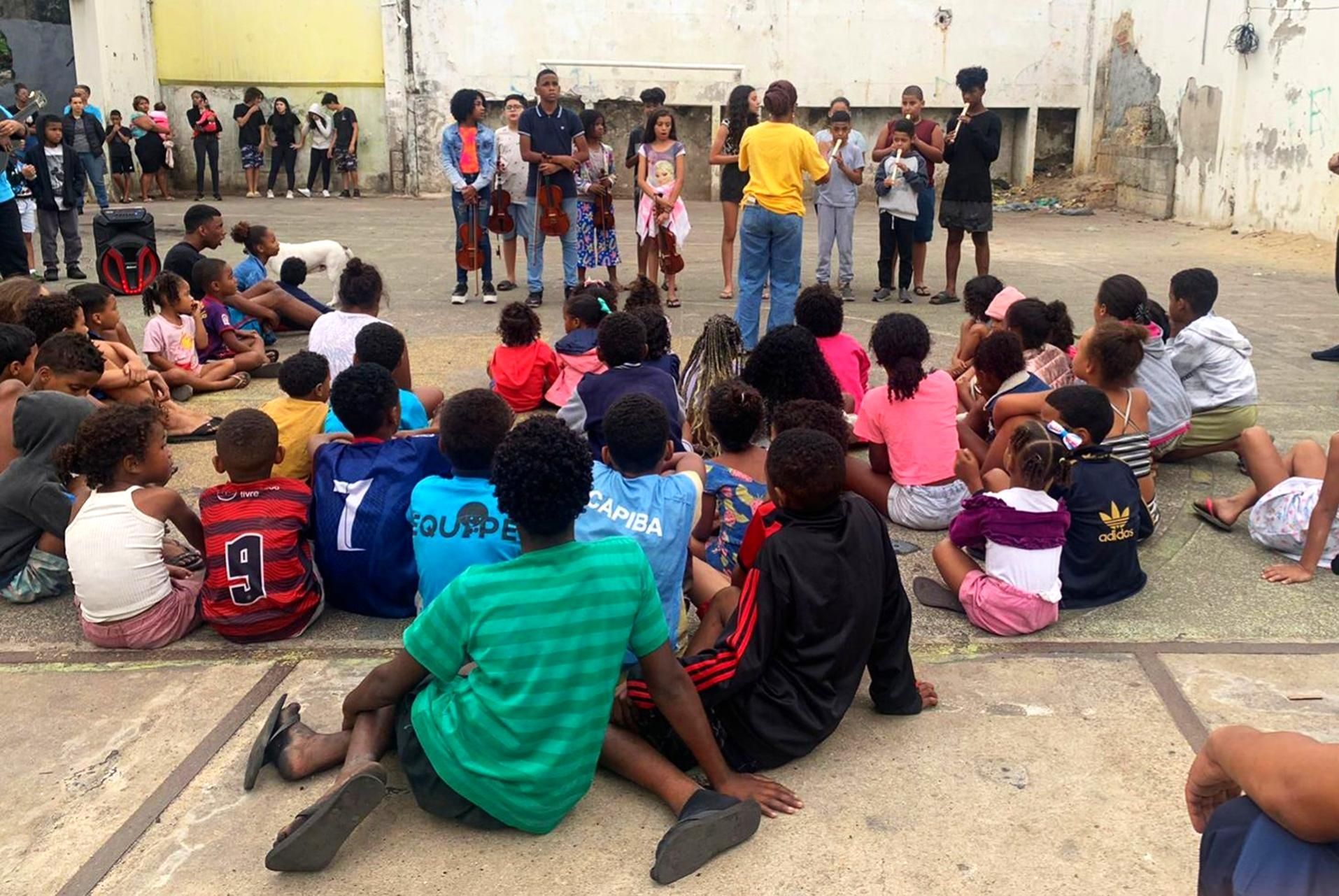 Um grupo de crianças está sentado em círculo e uma delas tem o número 7 na camisa