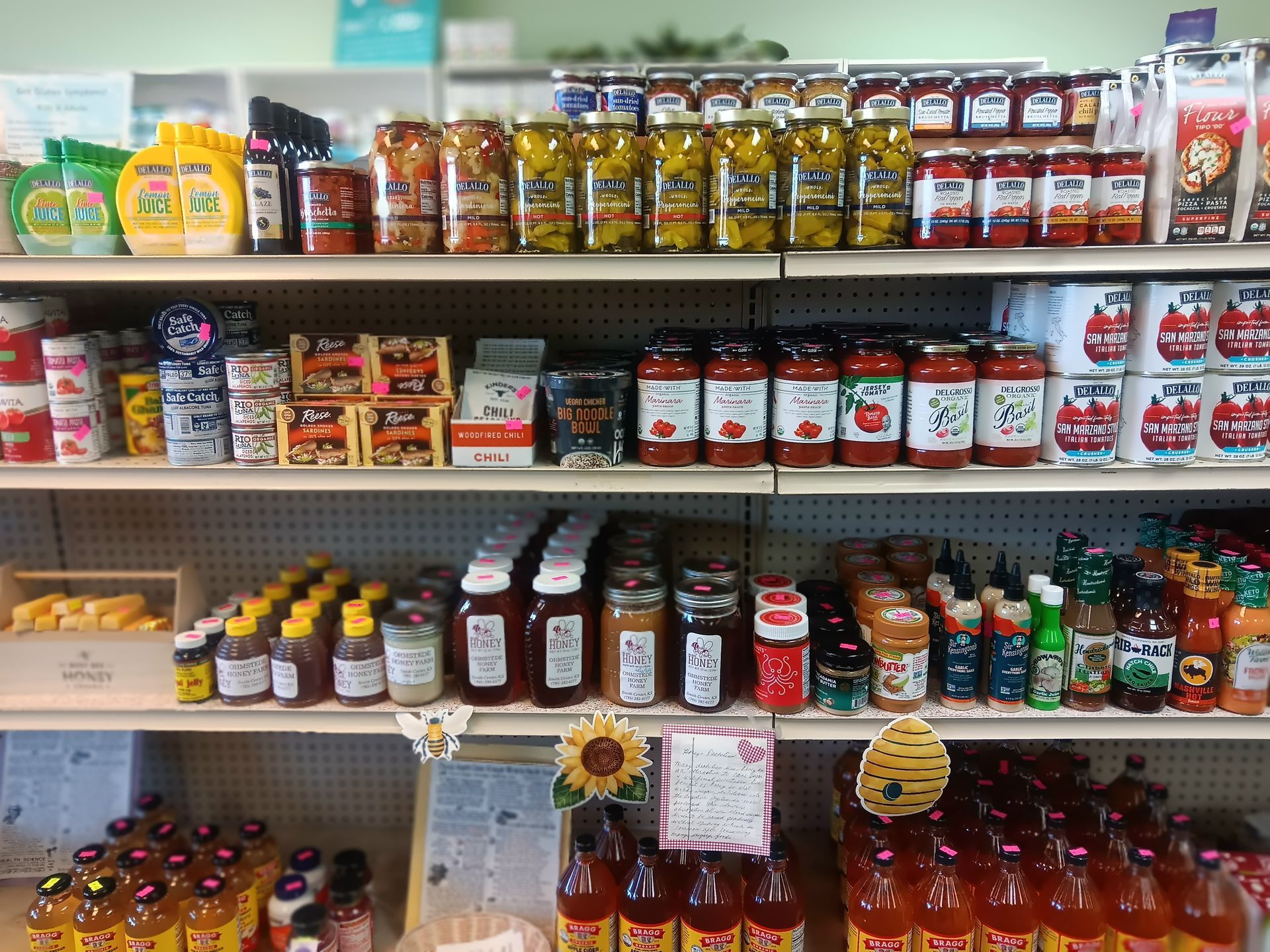 A grocery store shelf filled with jars and bottles of food.