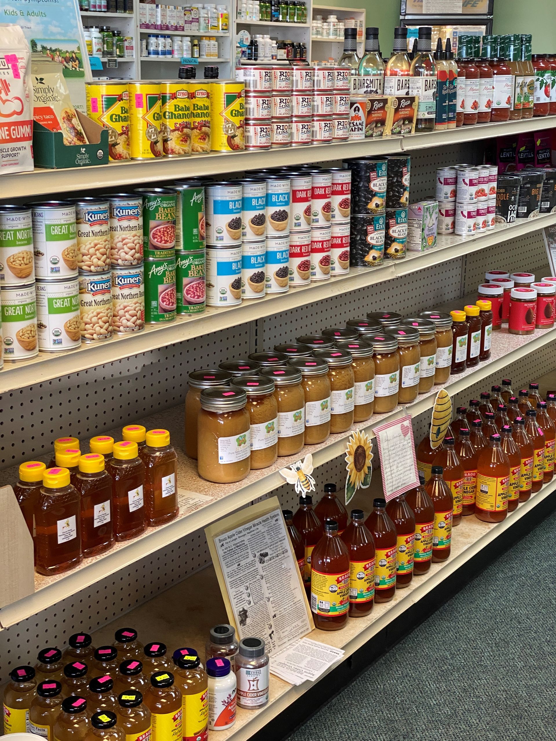 A grocery store shelf filled with cans , jars , and bottles of food.