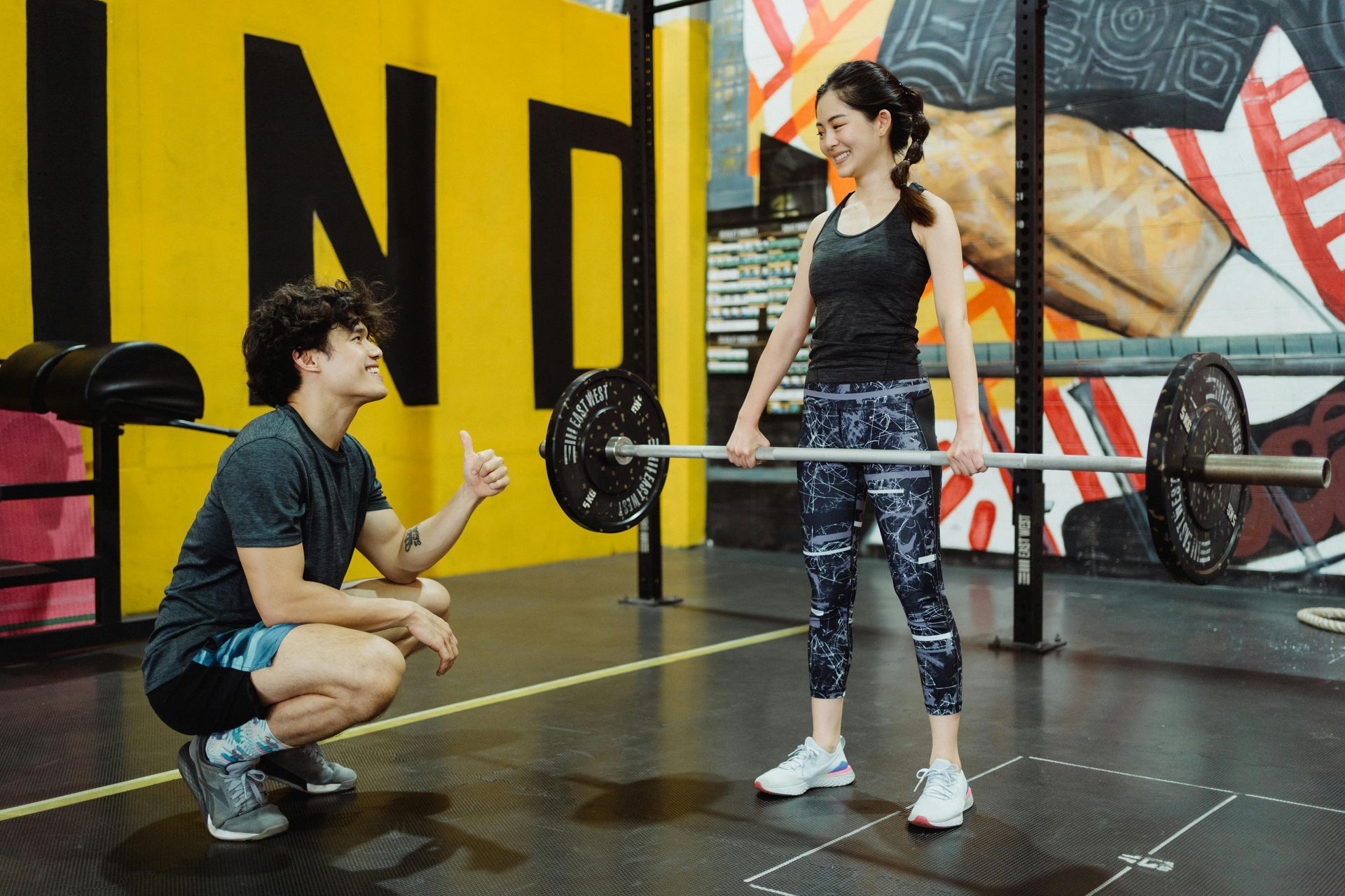 Personal trainer coaching client during weight loss workout in gym