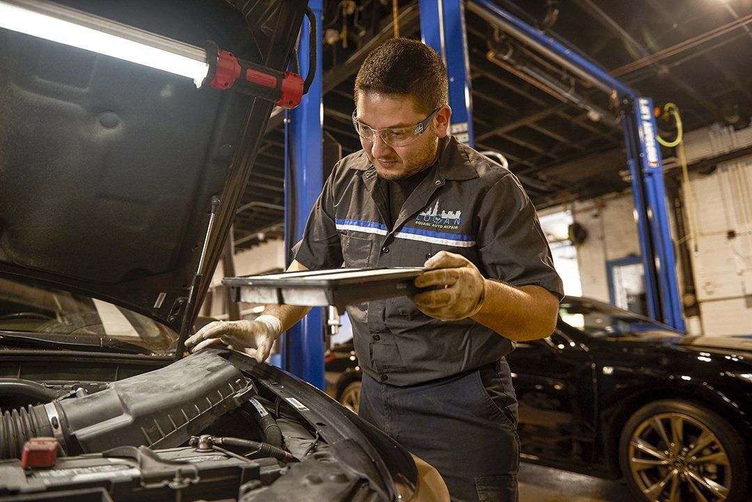 Mechanic inspecting a car engine in a garage, holding a clipboard under bright workshop lights