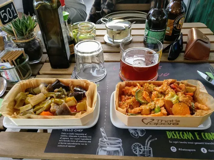 Due vassoi con pasti, birra e bevande su un tavolo in un ristorante.