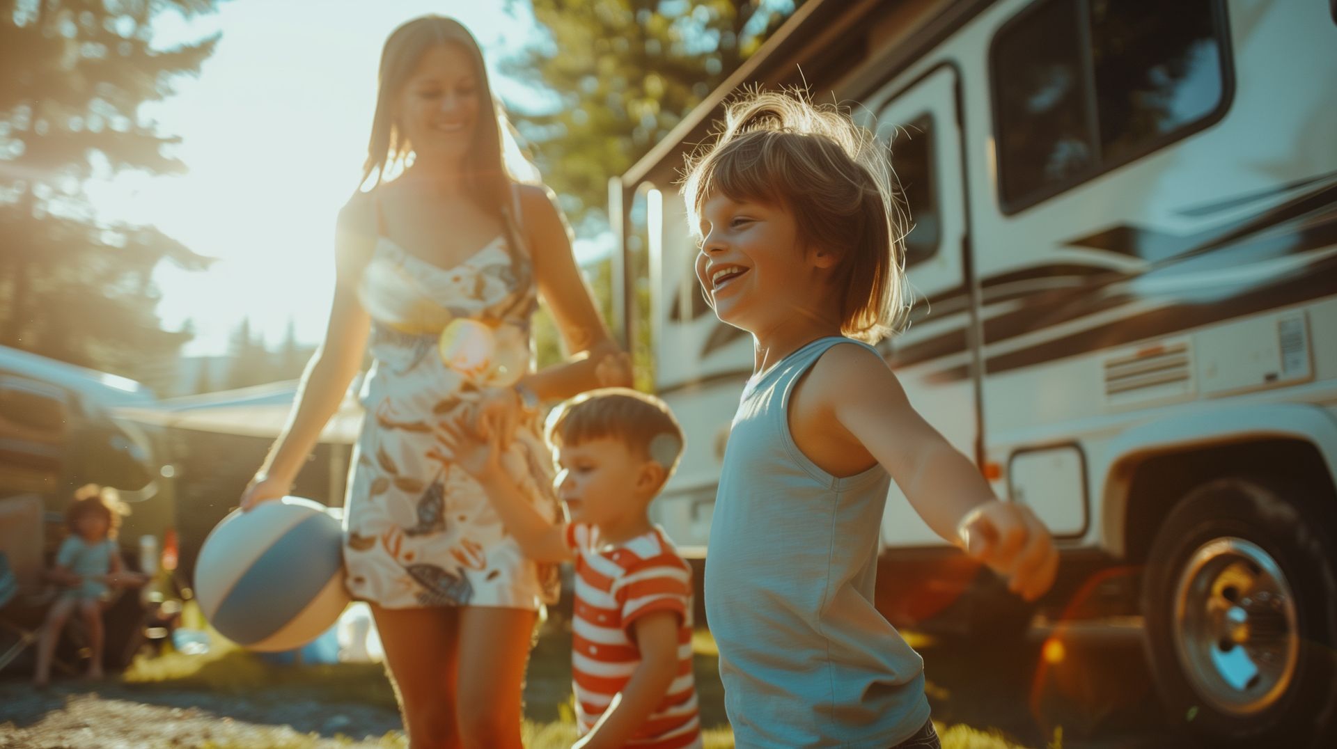 Two children playing with a ball beside an adult and a parked RV.