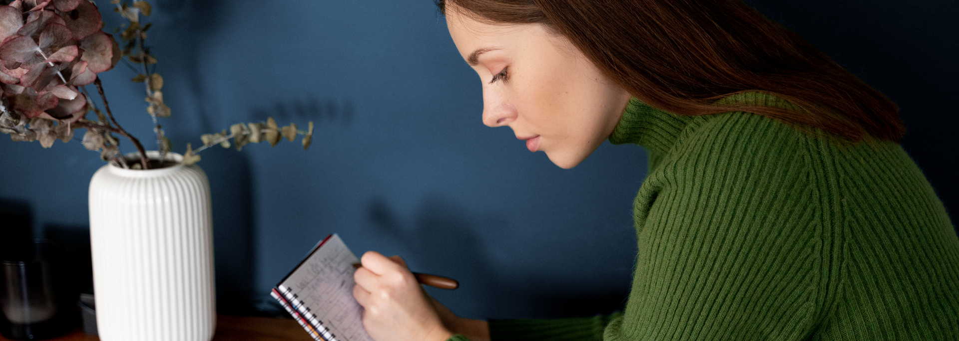 Picture of a person writing a list on a notepad.