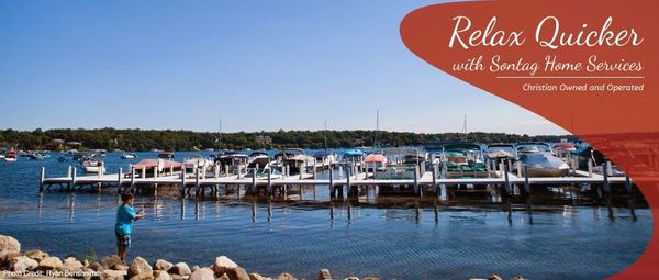 Covered boat dock on calm water with “Relax Quicker” text and a person standing at shore