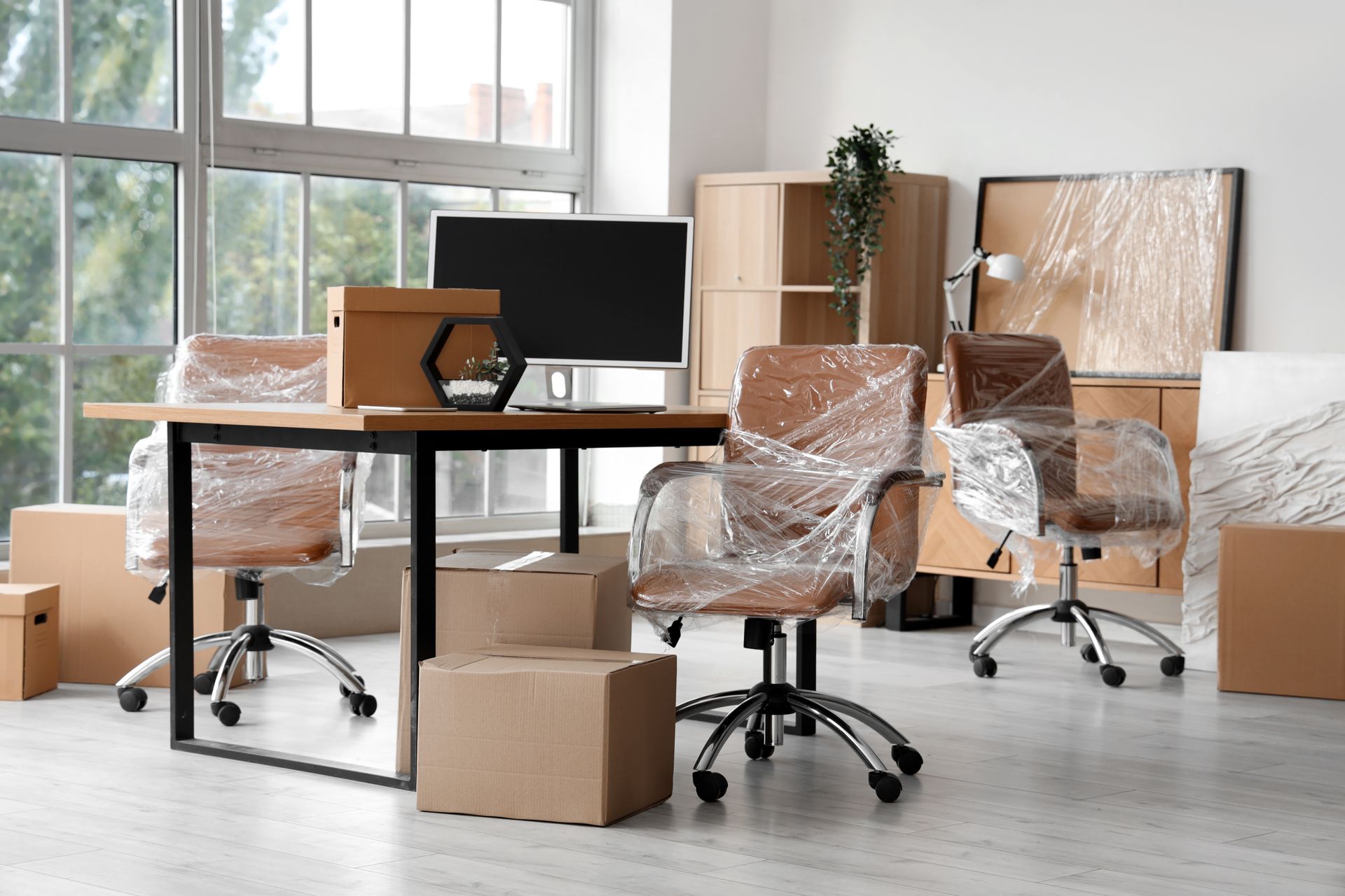 Interior of modern office with chairs wrapped in stretch film and cardboard boxes. Interior of modern office with chairs wrapped in stretch film and cardboard boxes.