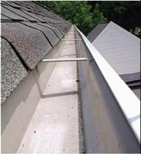 A clean, empty rain gutter runs along the edge of a shingled roof, supported by evenly spaced metal crossbars.