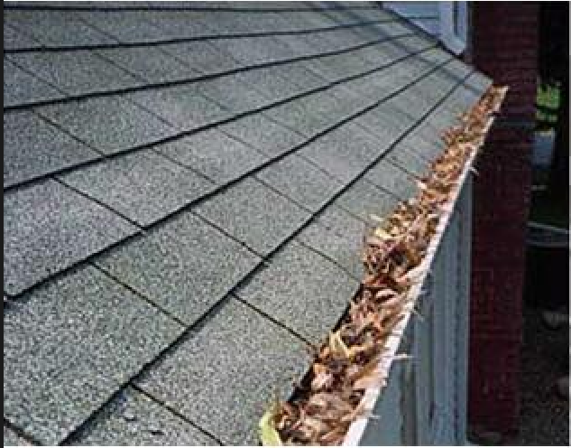 A roof gutter filled with dry, fallen leaves, highlighting the need for cleaning and maintenance.