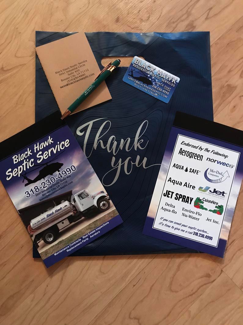 Promotional items: blue bag, notepad, pen, card, branded notepad with septic service truck, 