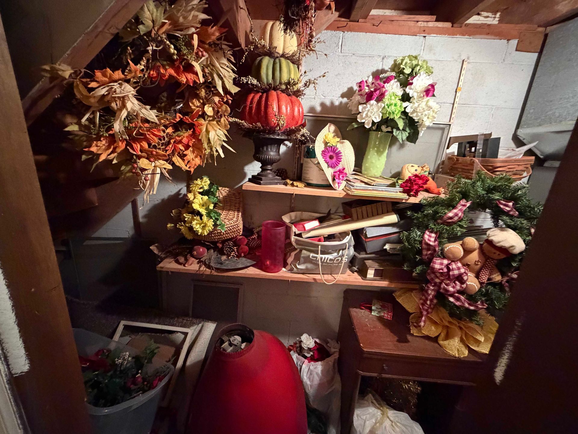 Flower arrangements and autumn decorations displayed on shelves in a rustic indoor setting.