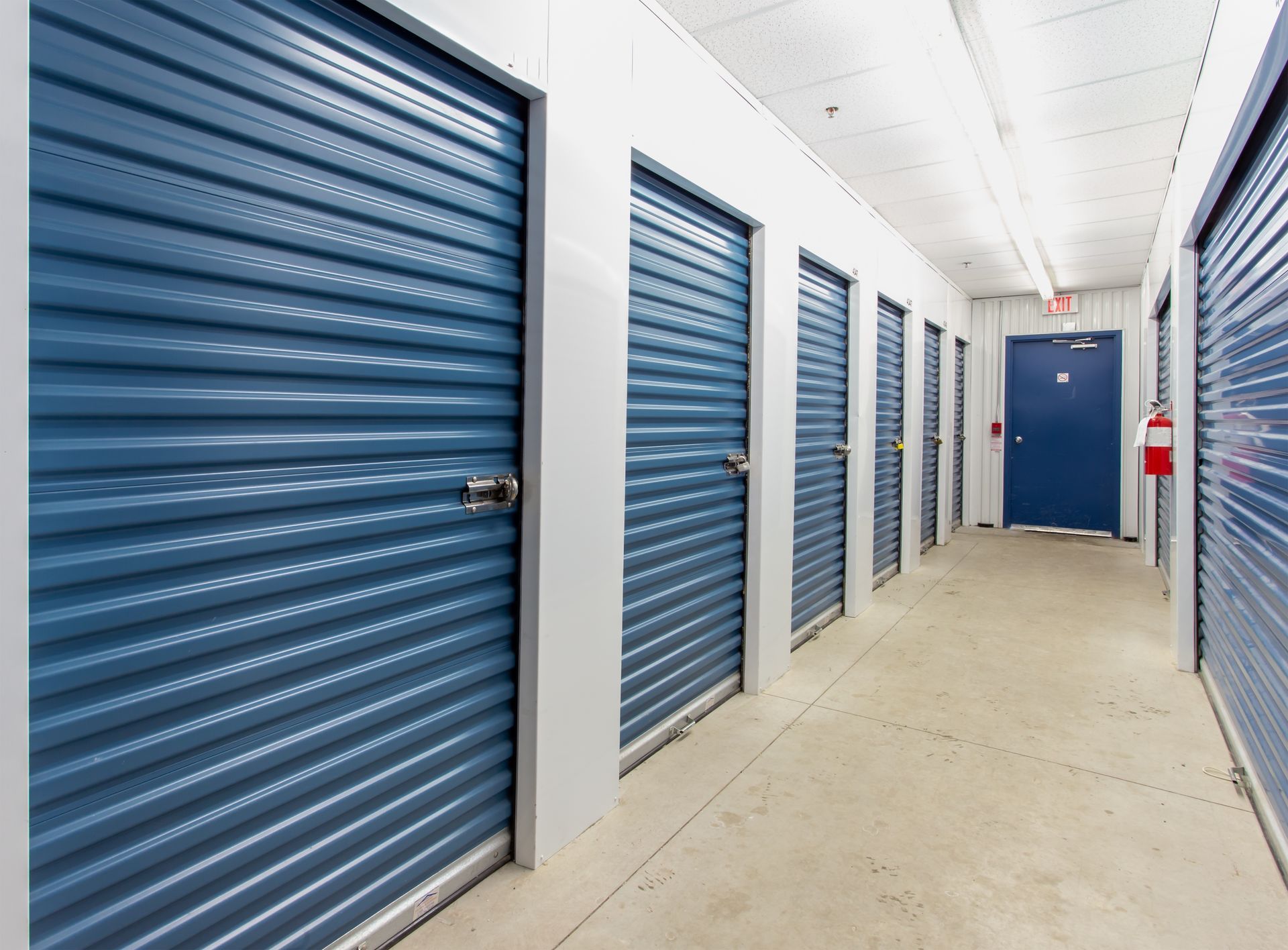 Hallway of blue storage unit doors in a self-storage facility