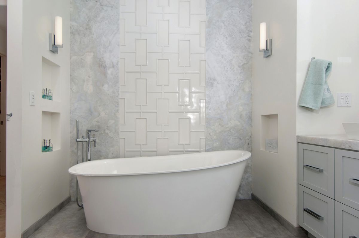 A bathroom with a walk in shower and a window.