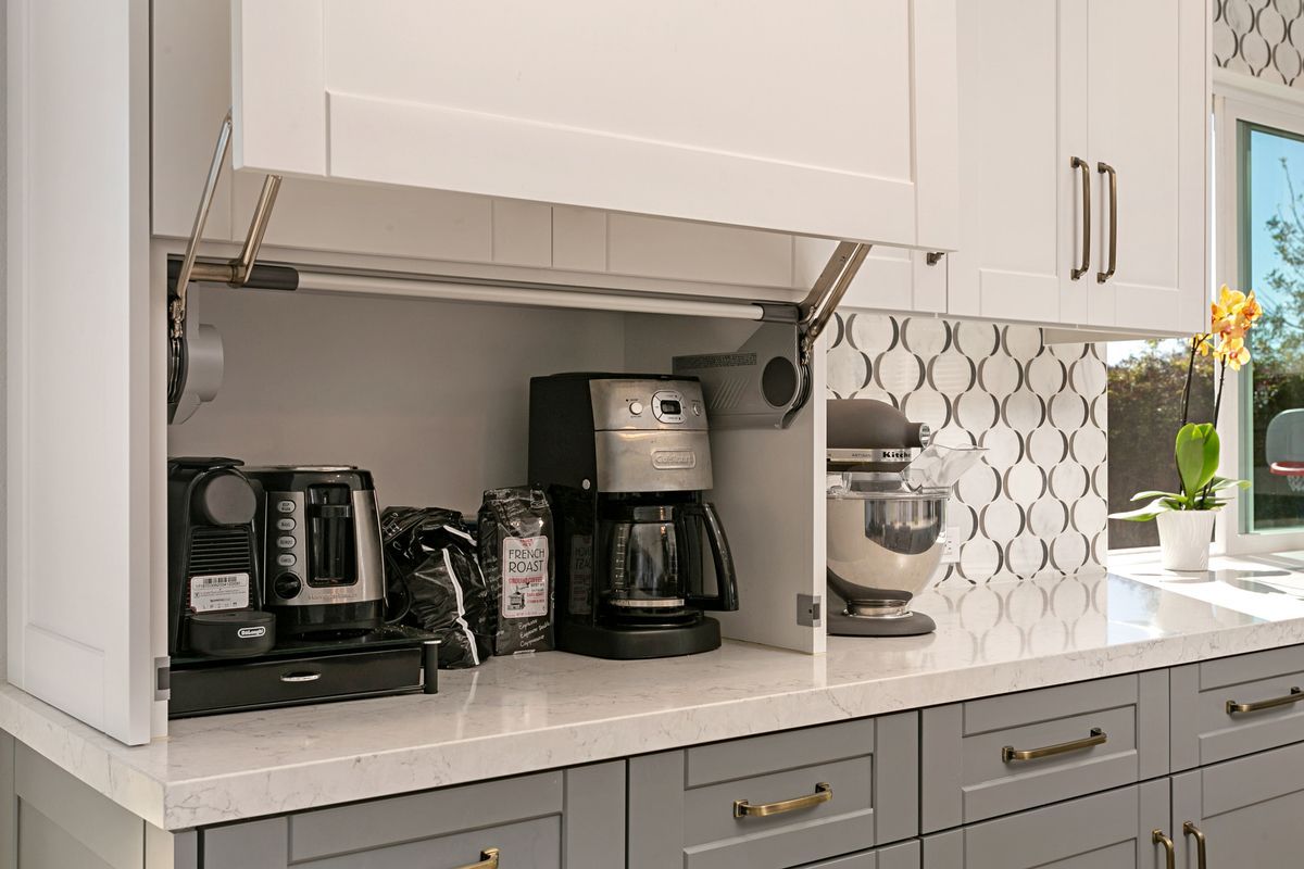 A kitchen with a coffee maker , kettle , and mixer.