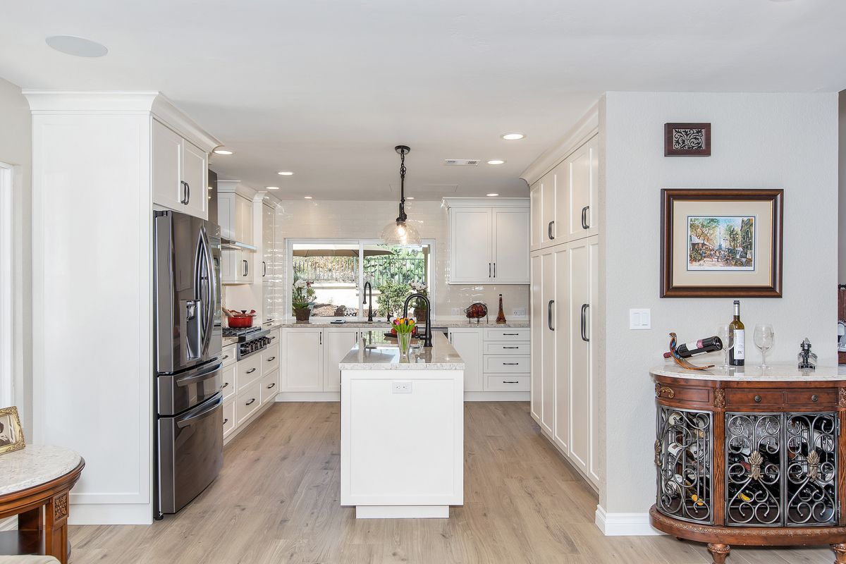 A kitchen with white cabinets and stainless steel appliances