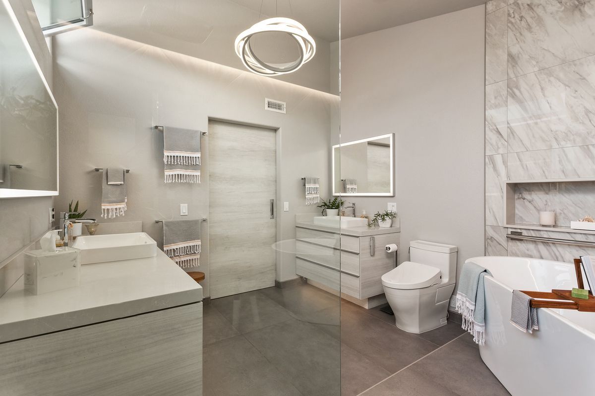 A bathroom with two sinks , a toilet , and a bathtub.