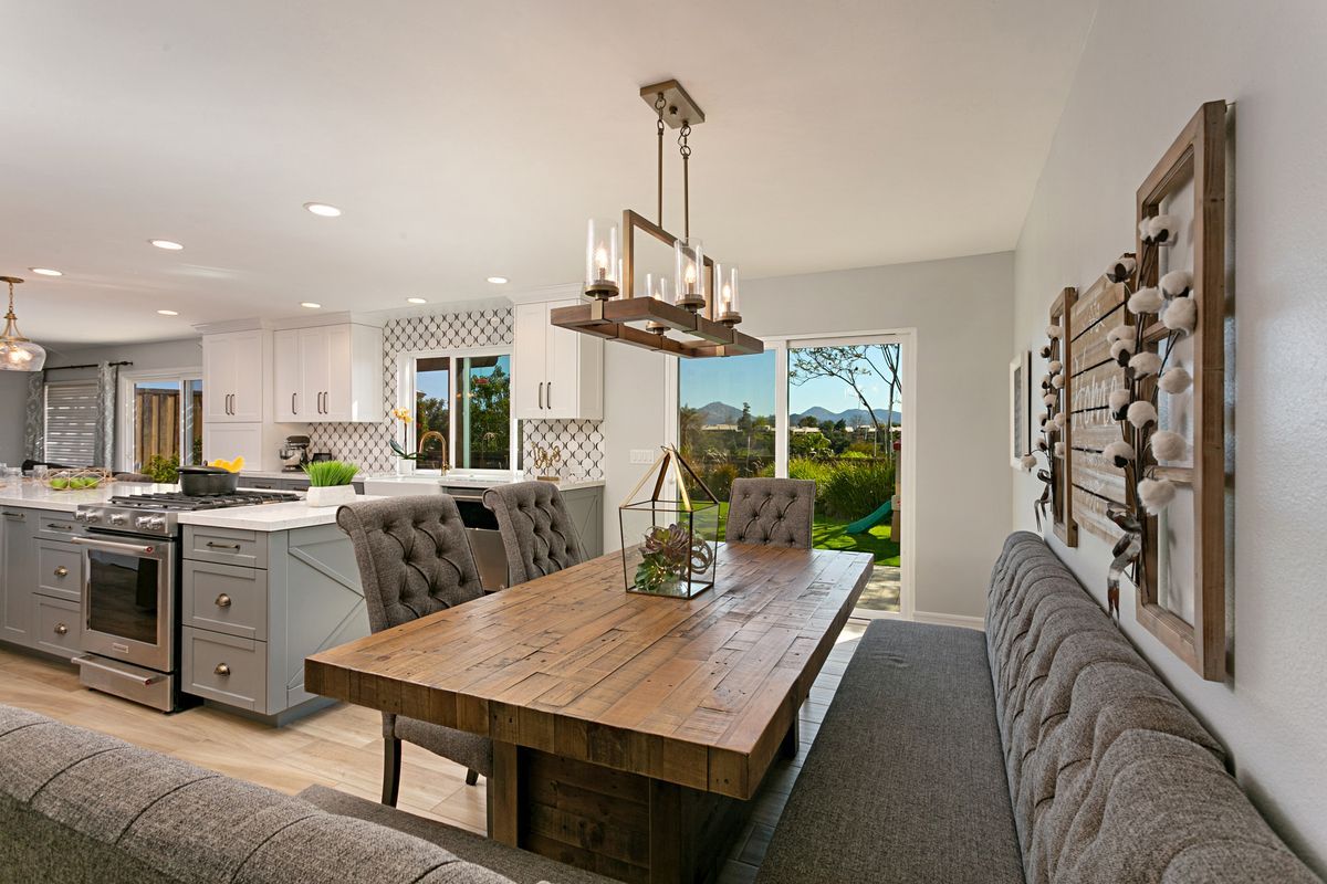 A dining room with a wooden table and chairs and a bench.