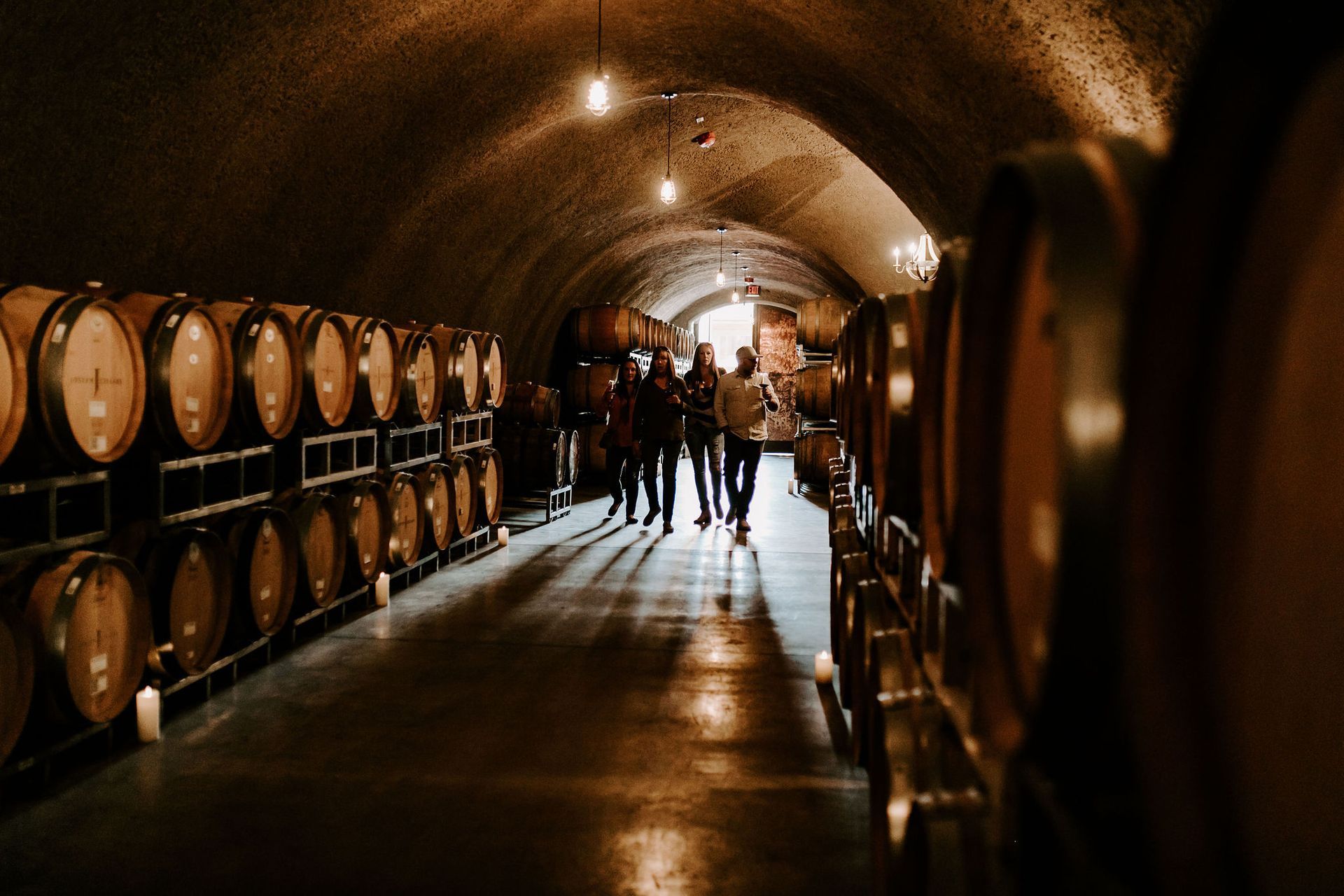 people walking through a wine cave