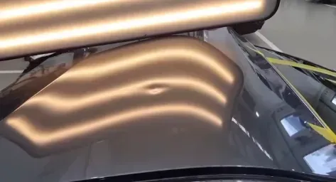 Mobile paintless dent removal technician working on a car in a Western Sydney driveway with tools la